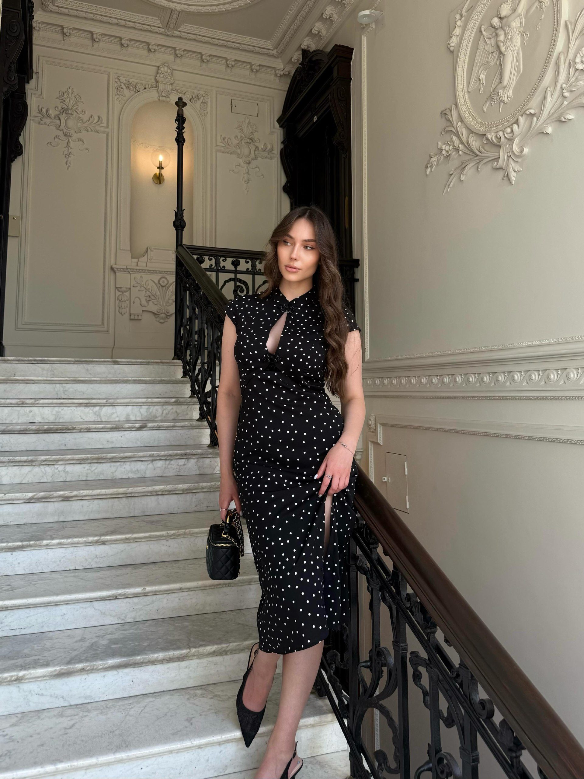 Editorial on a marble staircase, black polka-dot dress